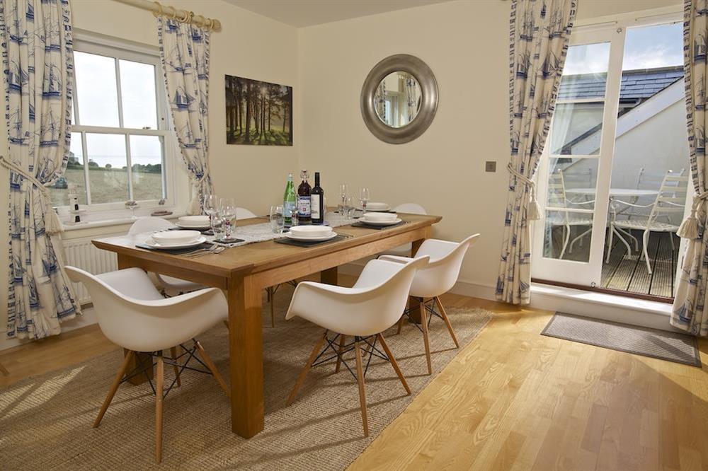 Dining table with seating for six and doors leading to the roof top terrace at Oceanview Apartment in Thurlestone, Nr Kingsbridge