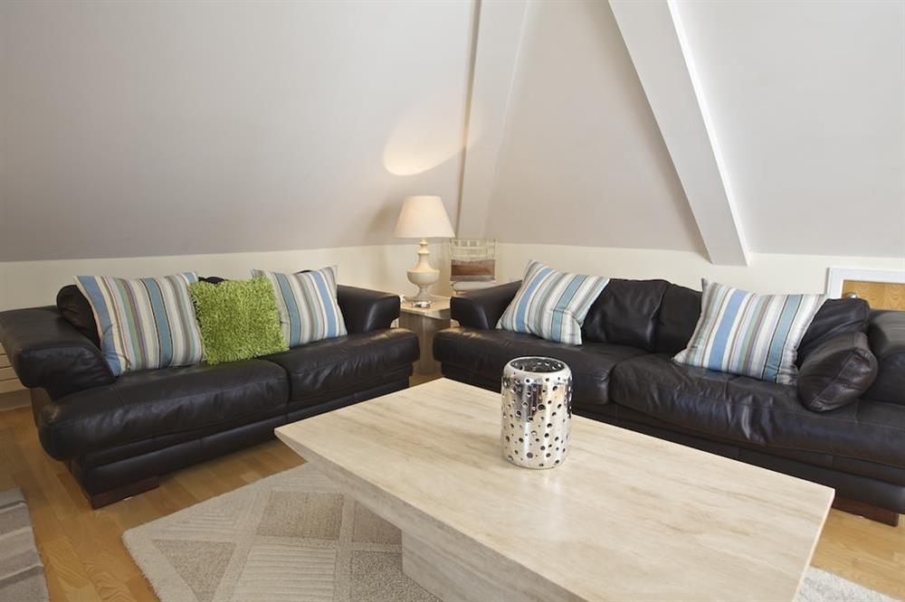 Spacious lounge area with large contemporary leather sofas and chairs at Oceanview Apartment in Thurlestone, Nr Kingsbridge
