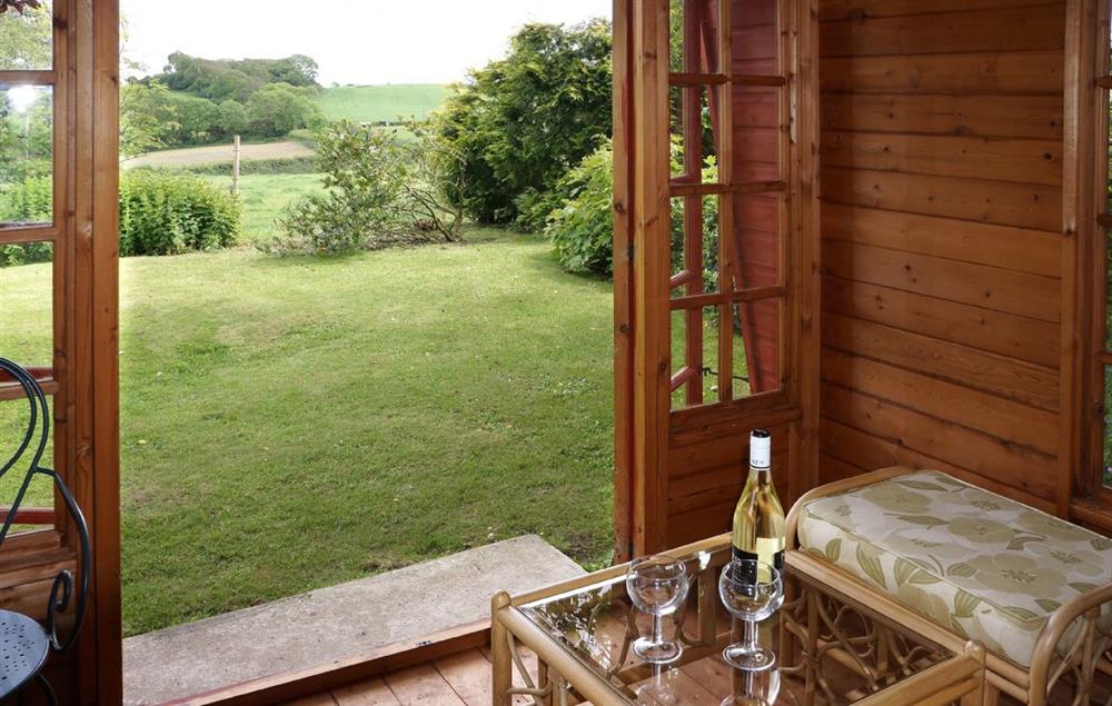 The summer-house looking out onto the gently sloping lawned garden at Odd Nod Cottage, Coombe Keynes