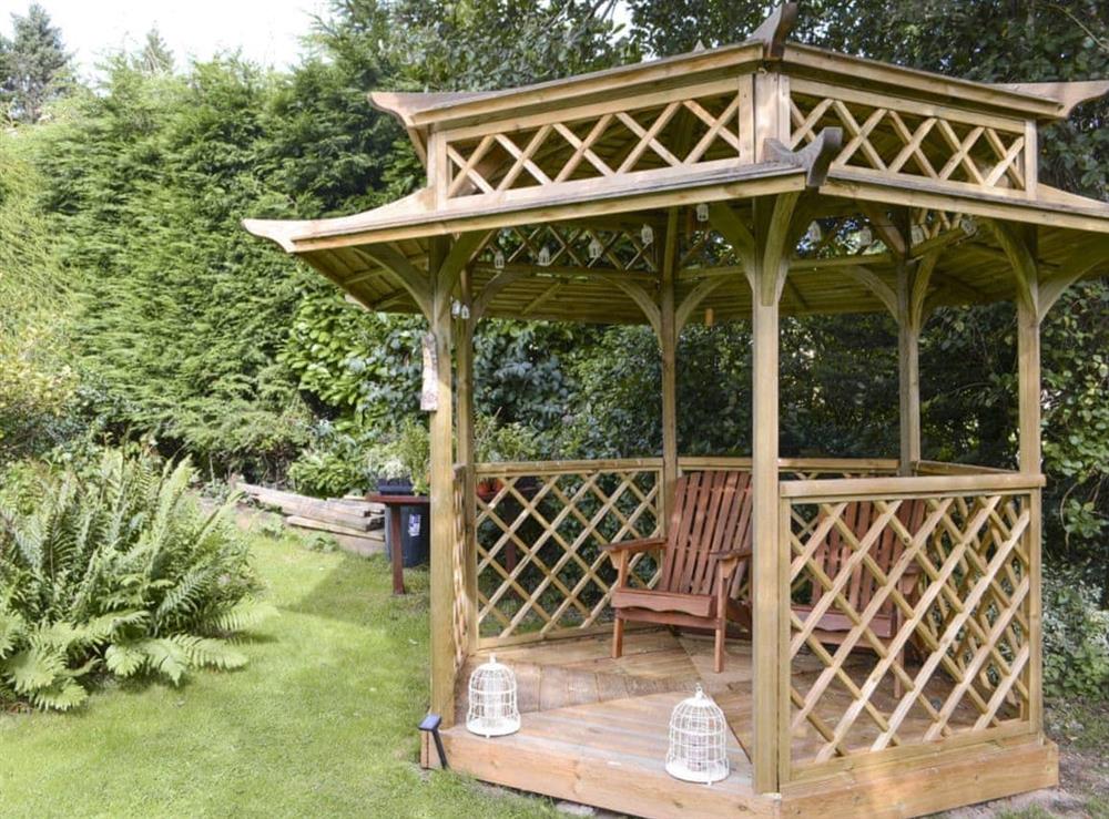 Pergola with seating within garden at Old Brewery Coach House in Melkridge, Northumberland