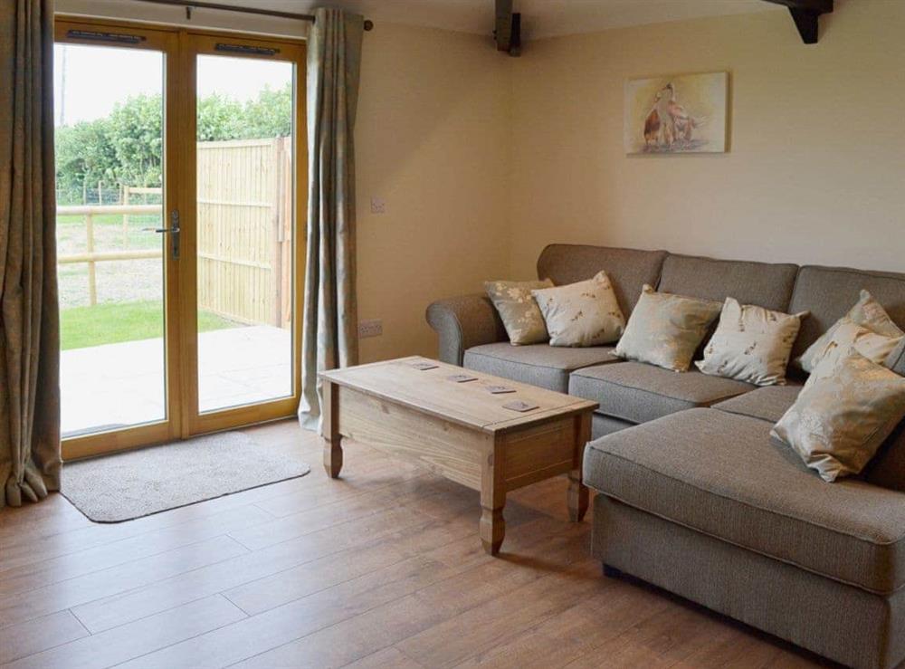 Cosy living area with French doors to garden and patio at Horseshoe Cottage, 