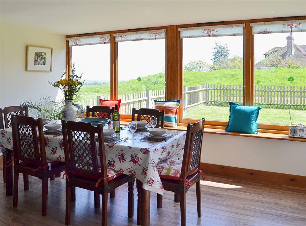 The grand dining table has a great view out of the panoramic windows at Old Dairy Barn in Playden, near Rye, East Sussex