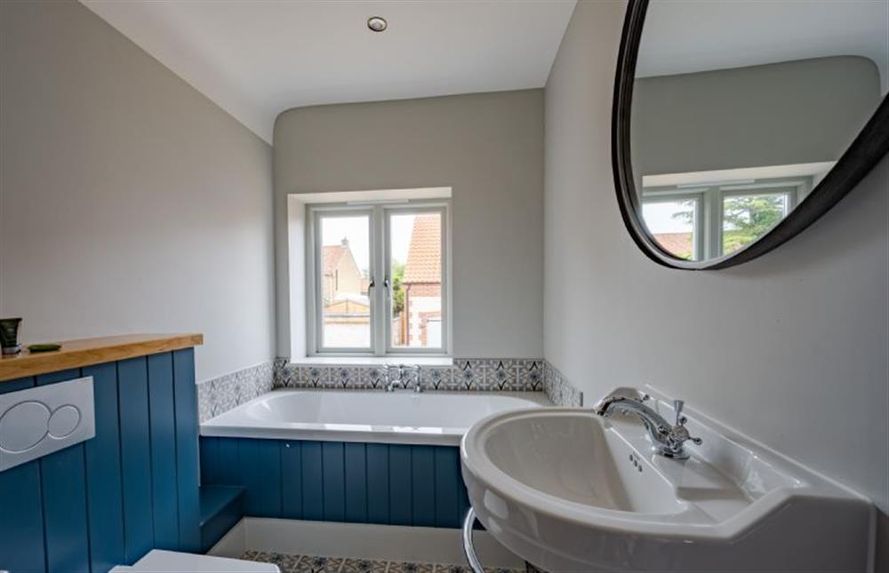 First floor: Bedroom four, en-suite bathroom with double ended bath at Old Farm, Thornham near Hunstanton
