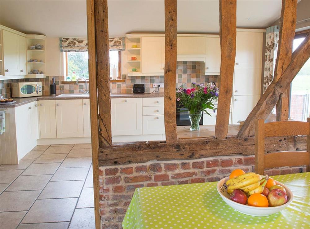Convenient dining area and well-equipped kitchen at Henrys Barn, 