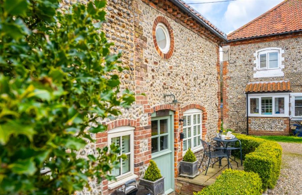 Courtyard (not enclosed) to the front of the cottage with a bistro table and chairs for two, and a charcoal barbecue