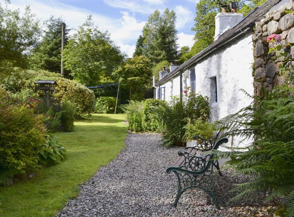 Enclosed lawned garden with sitting-out area, garden furniture and BBQ at Old Mill Cottage in Duror, near Appin, Highlands, Argyll