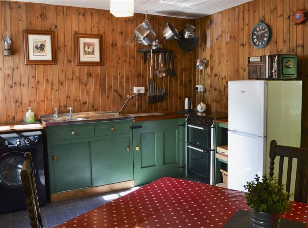Kitchen and dining room with wood burner at Old Mill Cottage in Duror, near Appin, Highlands, Argyll
