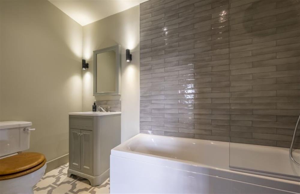 En-suite bathroom with bath with shower over at Old Mill House, Brancaster near Kings Lynn