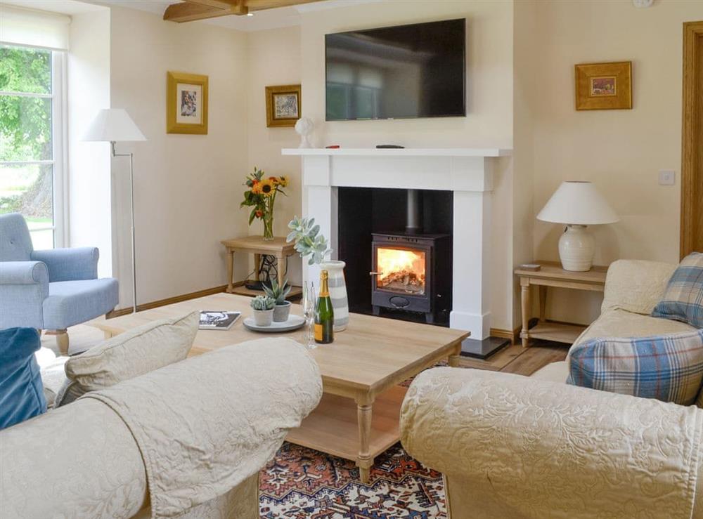 Stylish living room with wood burner at The Stables, 