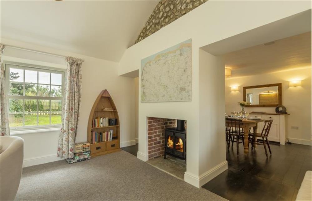 Ground Floor: A double-sided wood burning stove divides the rooms at Old Posting, Brancaster Staithe near Kings Lynn