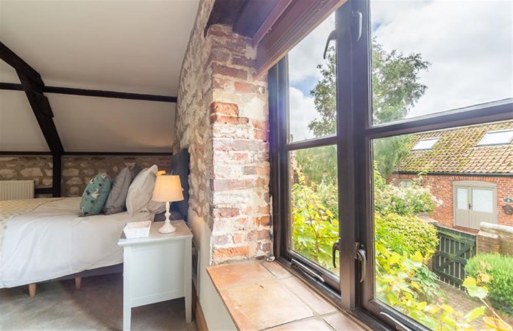 First floor: Master bedroom overlooking the courtyard garden at Old Smithy, Titchwell near Kings Lynn