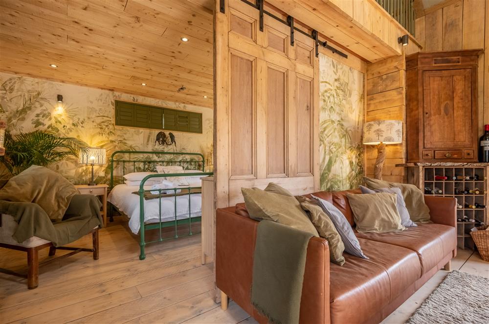 A sliding barn door reveals the romantic bedroom suite at Olive Tree House, Ripe, Lewes
