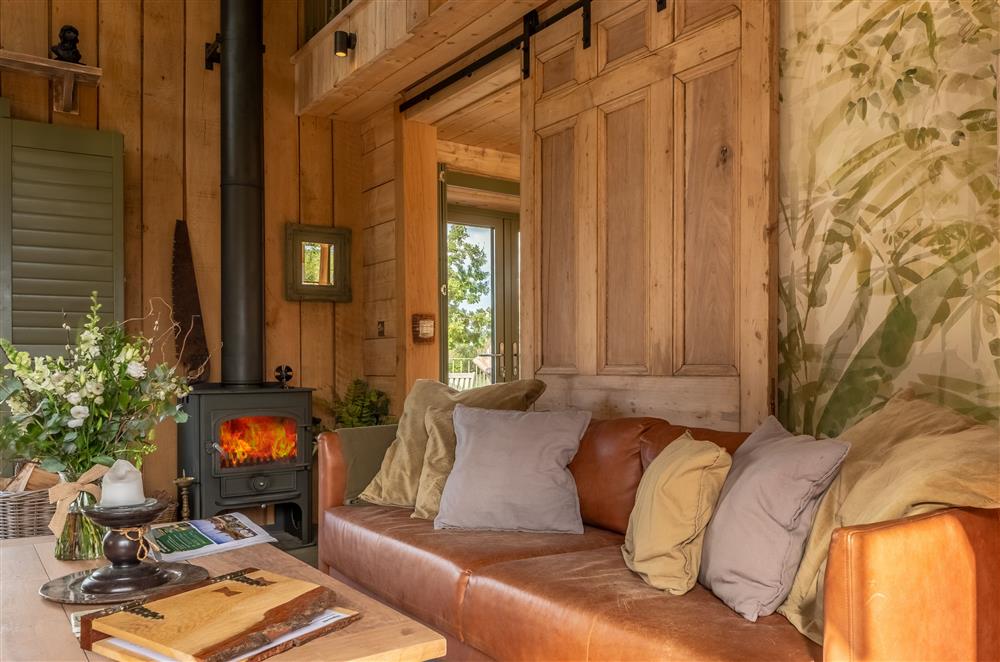 Cosy up in front of the wood burning stove on the comfy leather sofa