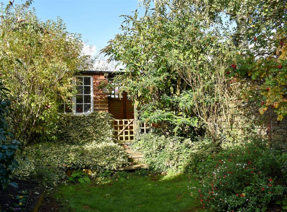 Small enclosed lawned garden at One Well Cottage in Holton, near Halesworth, Suffolk