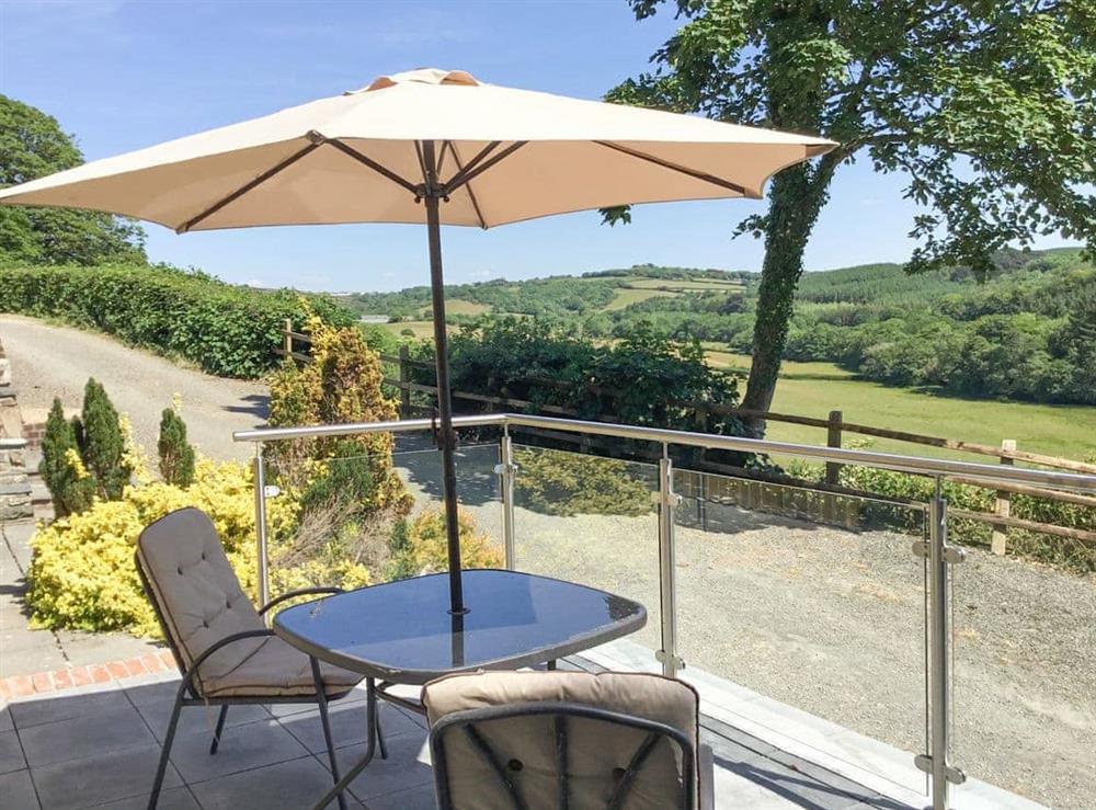 Relaxing patio area with shaded seating at Orchard Close in Morwenstow, near Bude, Cornwall