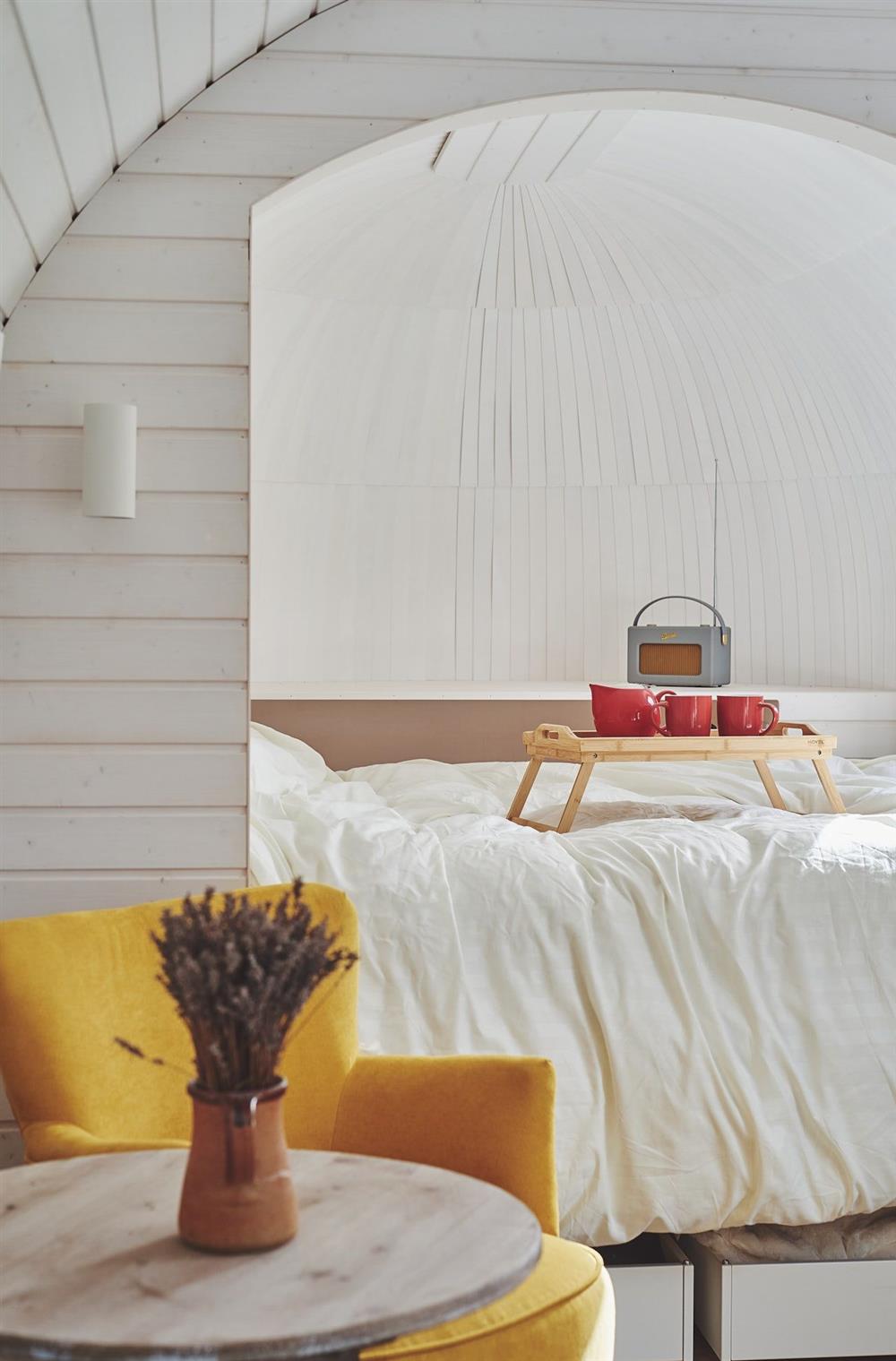 A yellow armchair and double bed