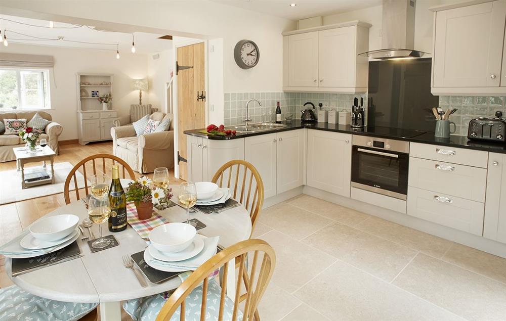 Open plan fully equipped kitchen and dining table seating four guests at Orchard View, Pulverbatch