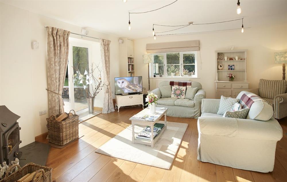 Open plan sitting room with wood burning stove at Orchard View, Pulverbatch