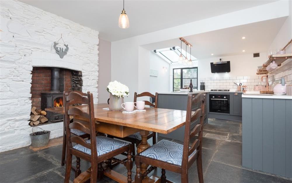 The dining end of the open planned room, with wood burning stove. at Osbornes, 2 Retreat Cottages in Wadebridge