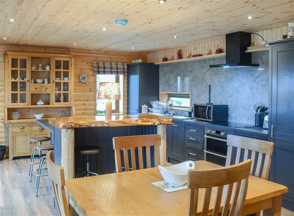 Modest dining area and adjacent kitchen at Osprey Lodge in Rogart, near Dornoch, Northern Highlands, Sutherland