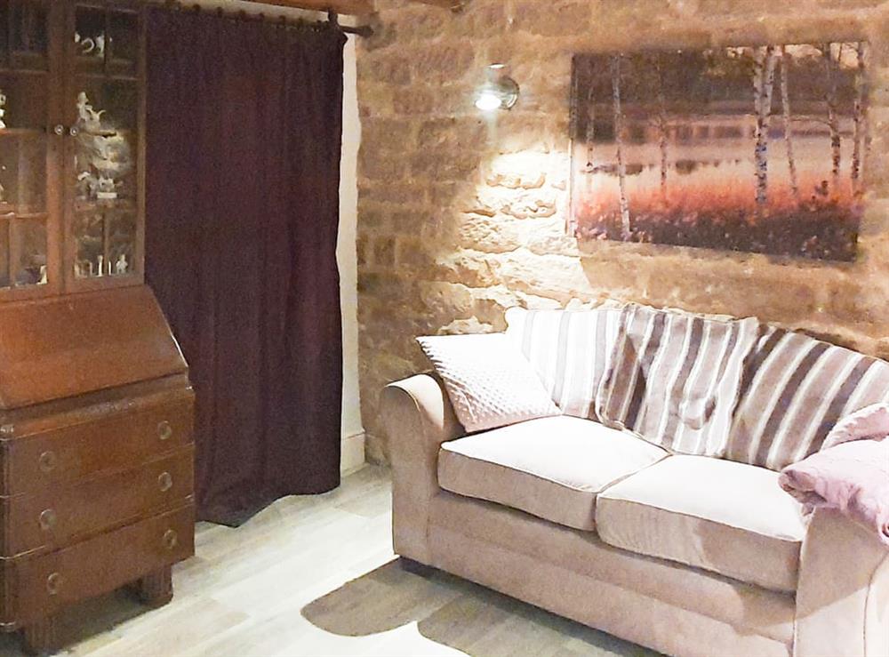 Exposed stone wall and low oak beams make this the perfect room for for cosy nights in at Owl Cottage in Crich, near Matlock, Derbyshire