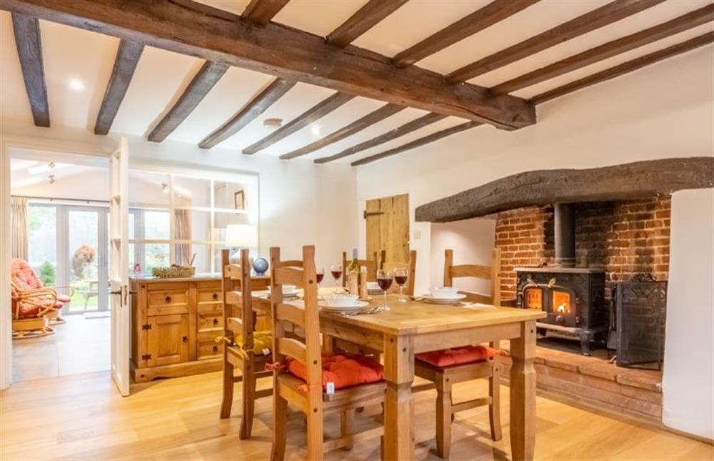 Dining room with beamed ceiling and wood burning stove at Owl Cottage, Great Snoring near Fakenham