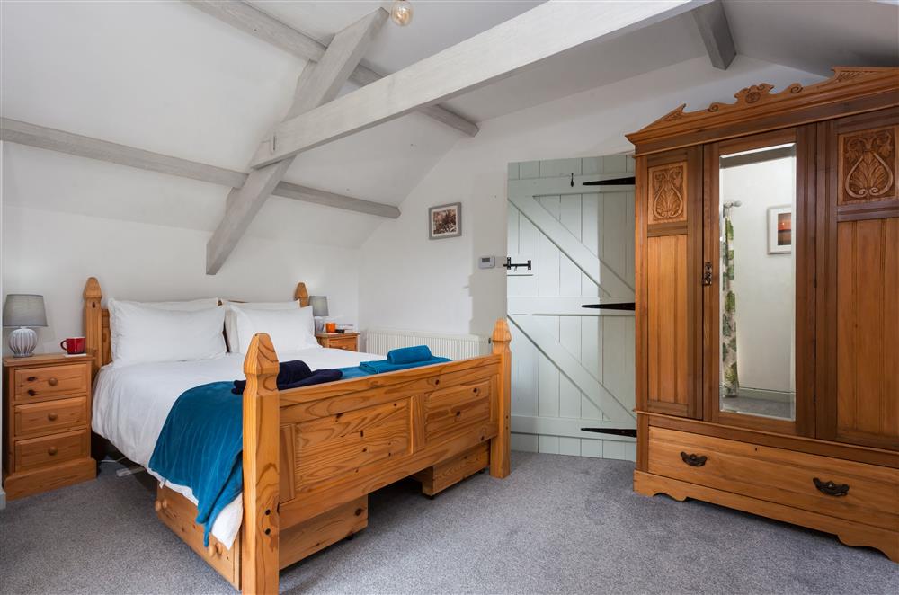 Bedroom one with a 5’ king-size bed at Owl Cottage, Llanwrda
