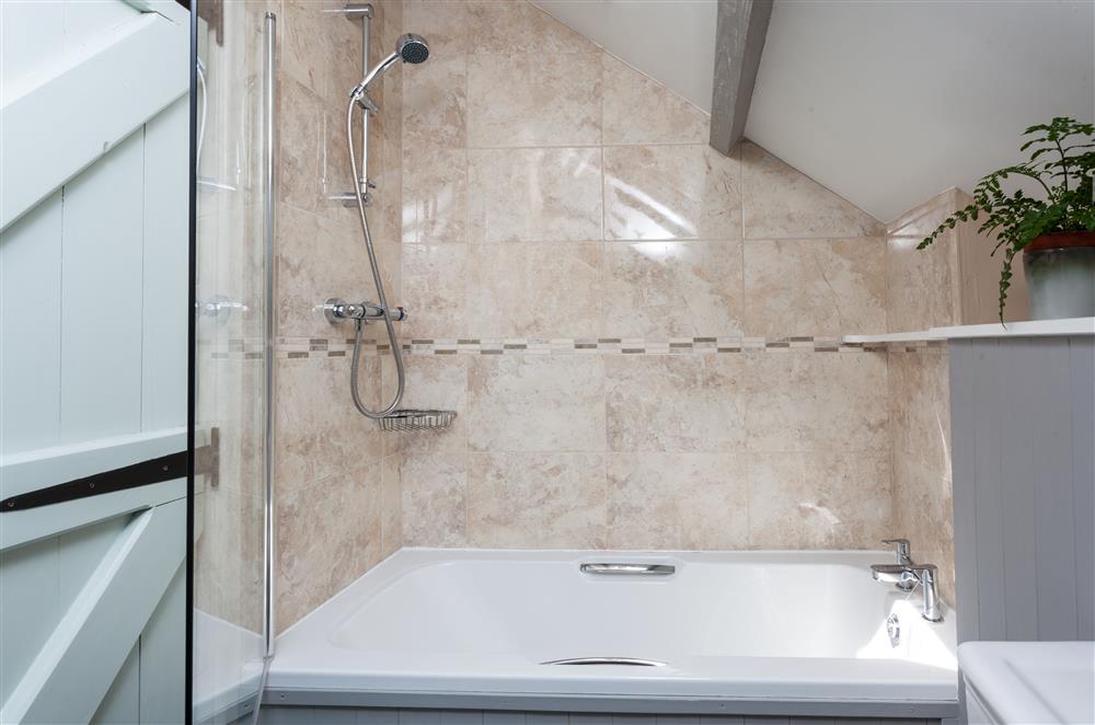 The family bathroom with a bath and overhead shower attachment at Owl Cottage, Llanwrda
