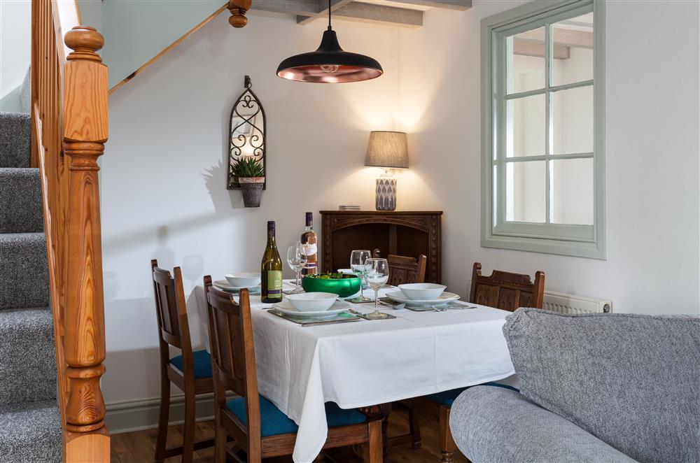 The open-plan sitting and dining area with stairs leading to the first floor at Owl Cottage, Llanwrda
