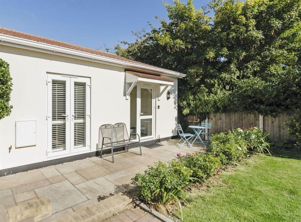 Enclosed lawned garden with terrace at Owls Croft in Broadstairs, Kent