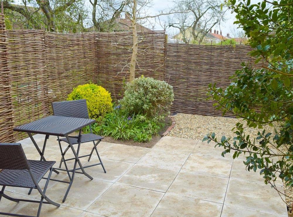 Small enclosed garden with patio and furniture at Owls Roost in Aldeburgh, Suffolk