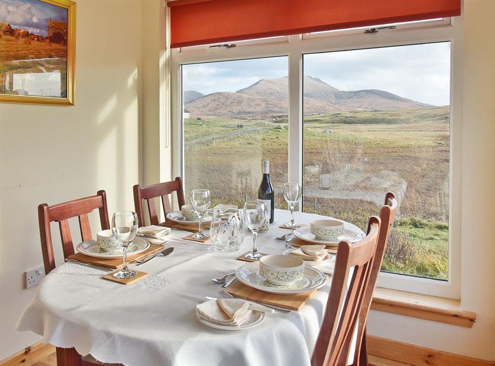 Sunny dining room with dramatic views of the hills at Padraigs Cottage in Howbeg (Tobha Beag), Isle of South Uist, Scotland