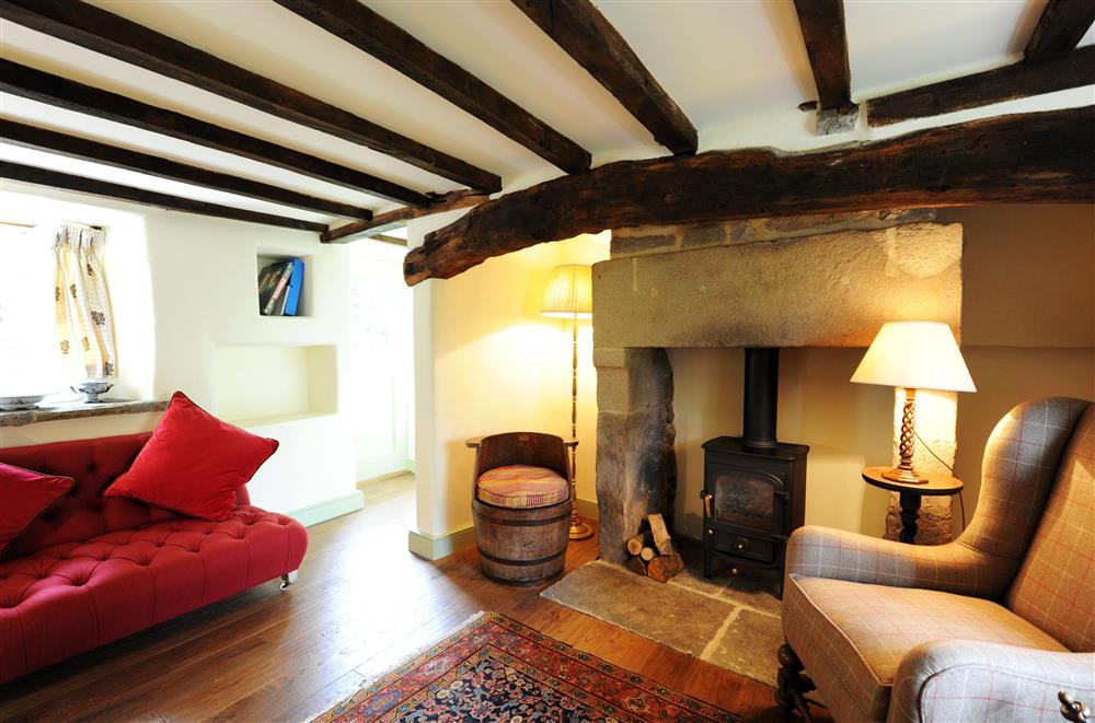 The cosy sitting room with wood burning stove and exposed beams at Park Cottage, Chatsworth Estate, Baslow, Nr Bakewell