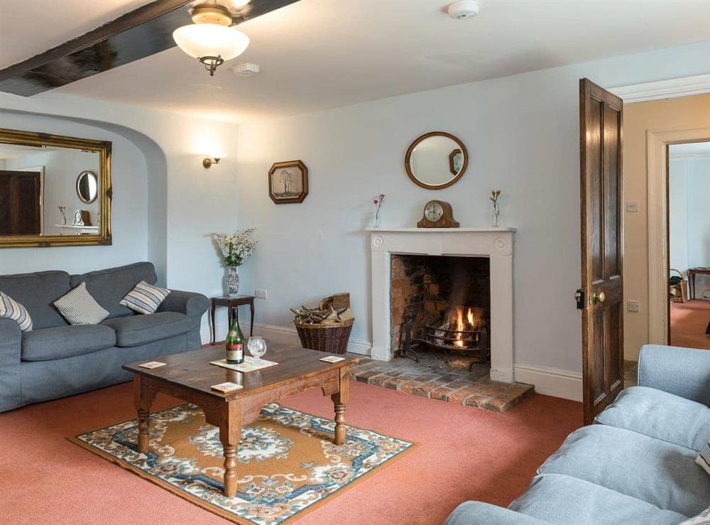 Living room with open fire at Park Farmhouse in Chideock, near Bridport, Dorset