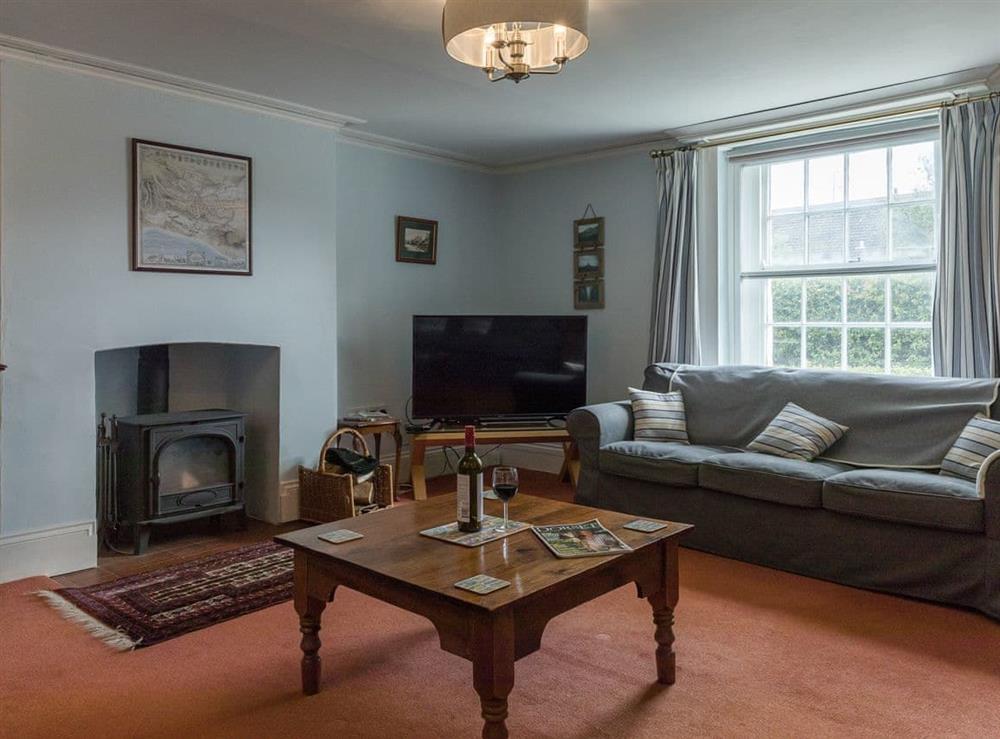 Living room with wood burner at Park Farmhouse in Chideock, near Bridport, Dorset