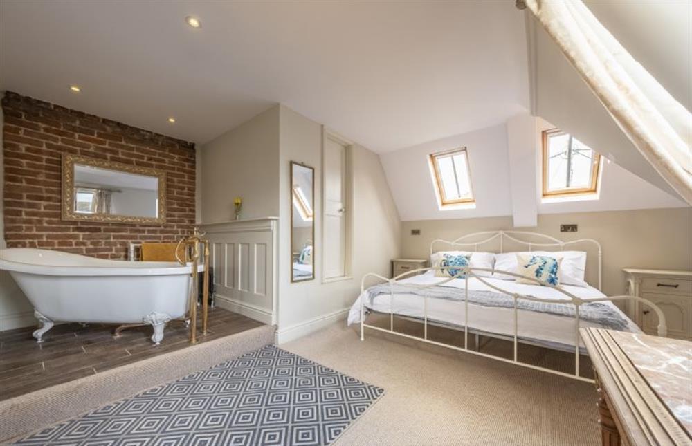 Master bedroom with superking-sized bed and roll top bath at Park Lodge, Snettisham near Kings Lynn