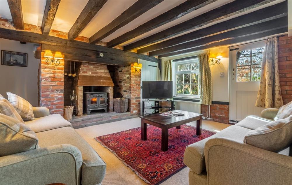 Sitting room with wood burning stove at Peak Hill Cottage, Theberton