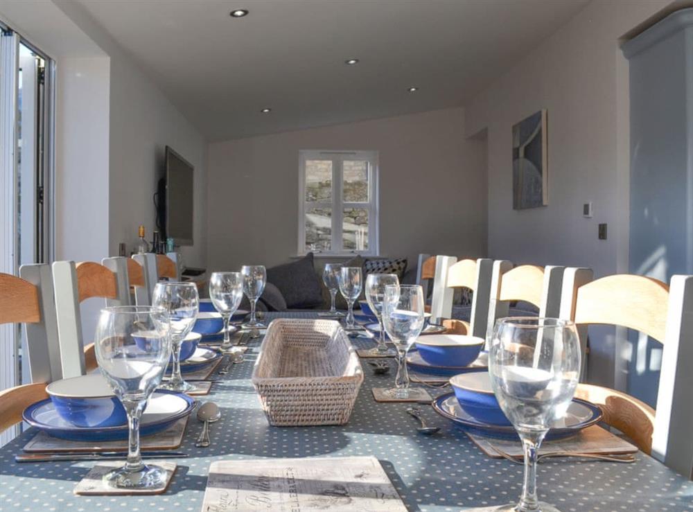 Dining area with a large banquet-style dining table at Pear Tree Cottage and The Granary in East Witton, near Leyburn, North Yorkshire
