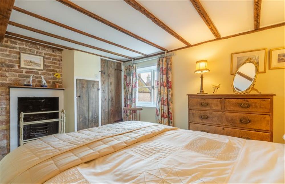 Master bedroom with feature decorative fireplace at Pear Tree Cottage, Blakeney near Holt