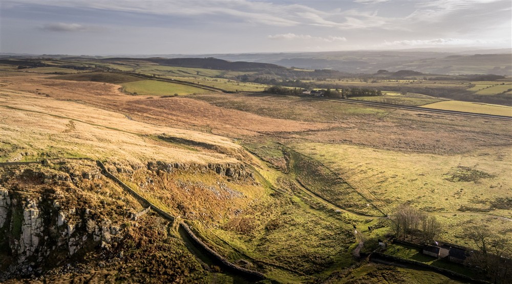 An aeriel photo showing the countryside to the south of the Peel Cottage, with the cottage in the bottom right corner and Hadrians Wall in the bottom left, Northumberland at Peel Cottage in Hexham, Northumberland