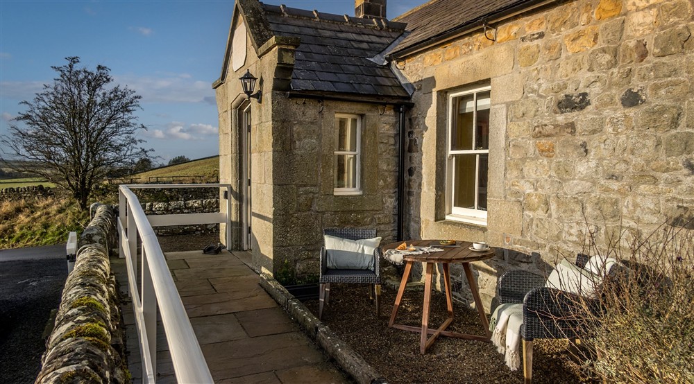 The ramp to the front door of Peel Cottage and outdoor dining area, with a table and two chairs, Northumberland at Peel Cottage in Hexham, Northumberland