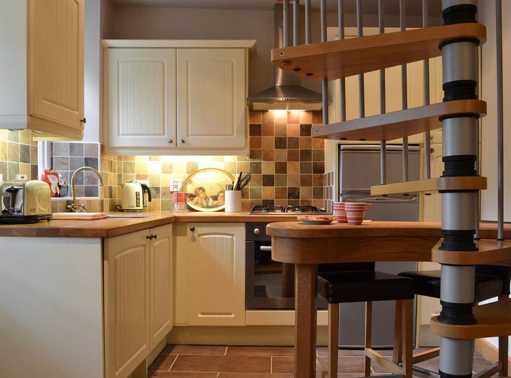 Kitchen area with spiral stairs at Pegs Place in Bowness-on-Windermere, Cumbria
