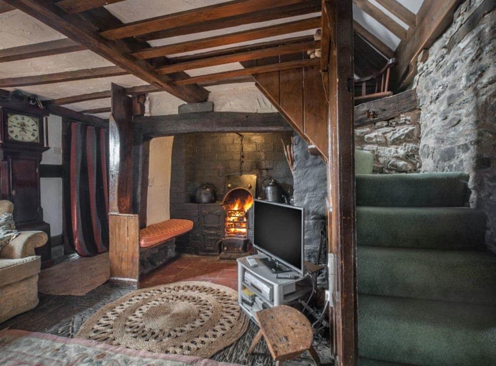 Living room with cobbled floor, open fire & many original features at Pen Copi in Trefeglwys, near Caersws, Powys