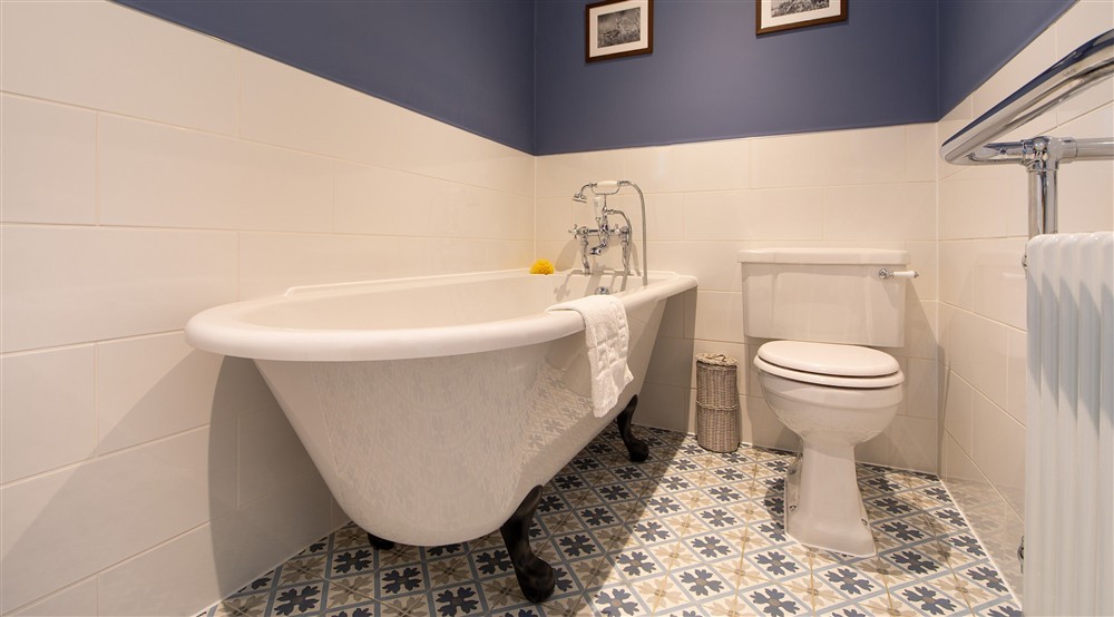 The en-suite bathroomto the second double bedroom, with a roll-top bath and walk-in shower, at Pengirt in Polzeath, Cornwall