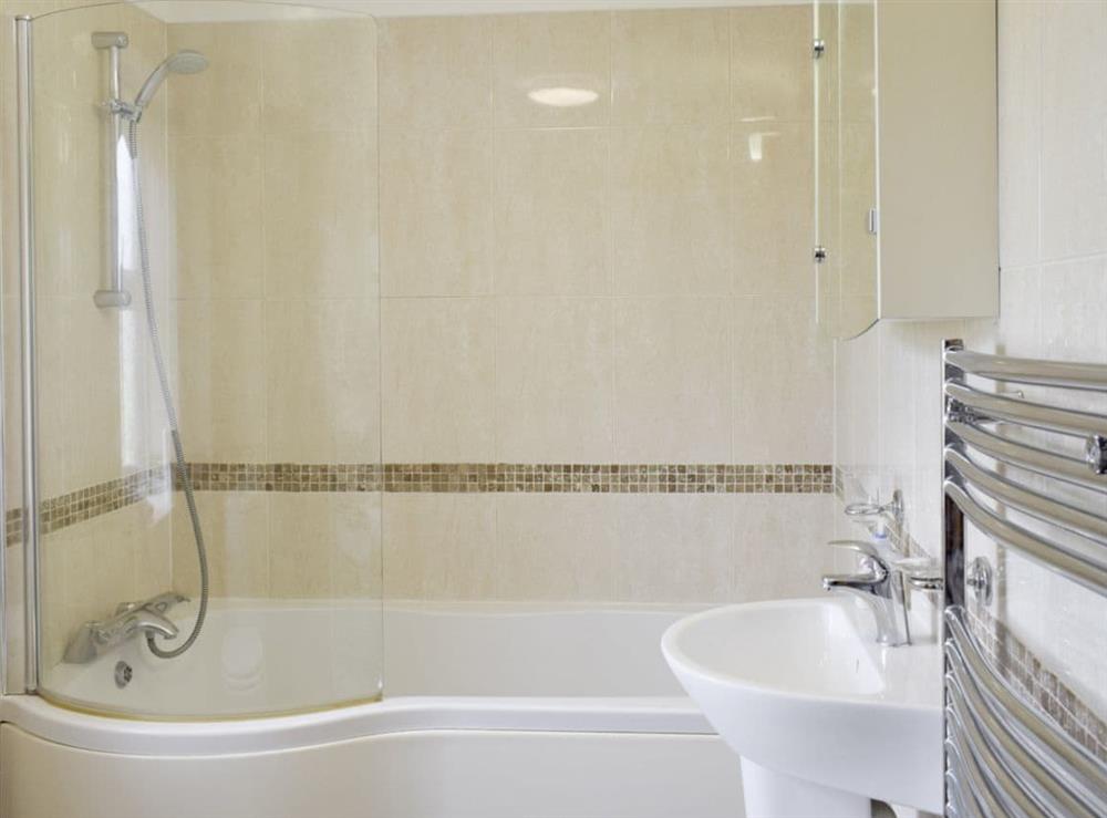 Light and airy bathroom with shower over bath at No 2 Pengraig Draw, 