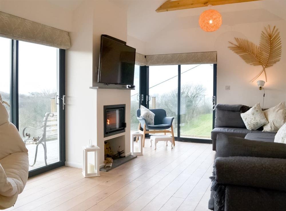Cosy living room with vaulted ceiling and sliding doors to the deck at Pengwyn in Trethevy, near Tintagel, Cornwall