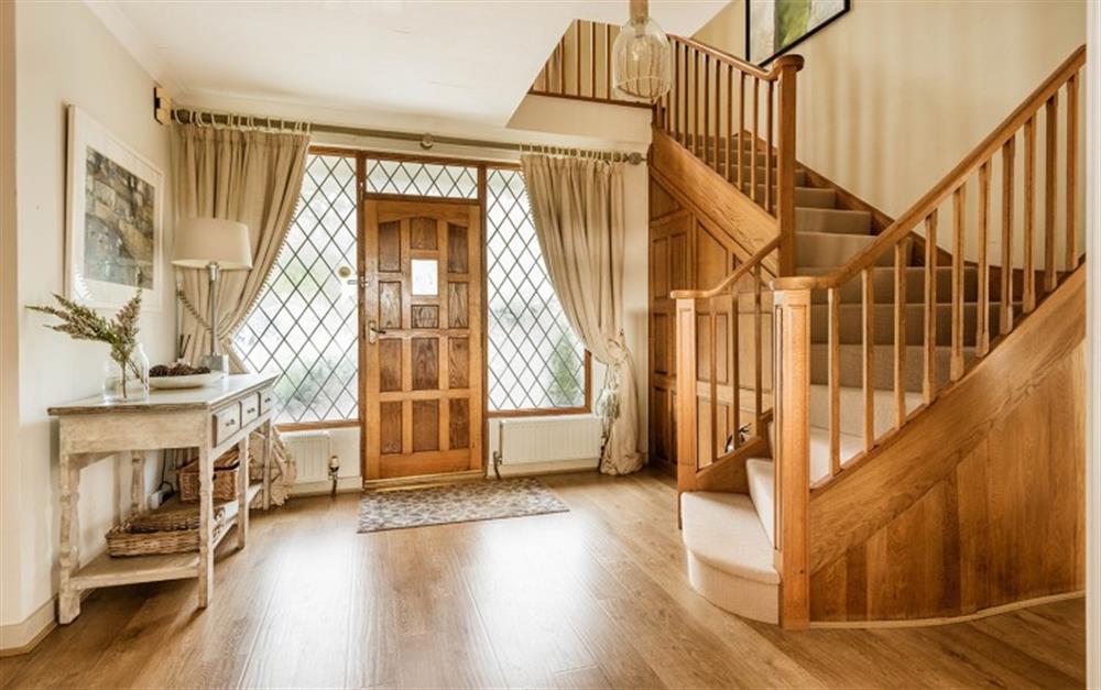 The front door opens into a beautiful hallway, complete with original wood panelling and a curved stairway. at Penmorva in Helford Passage