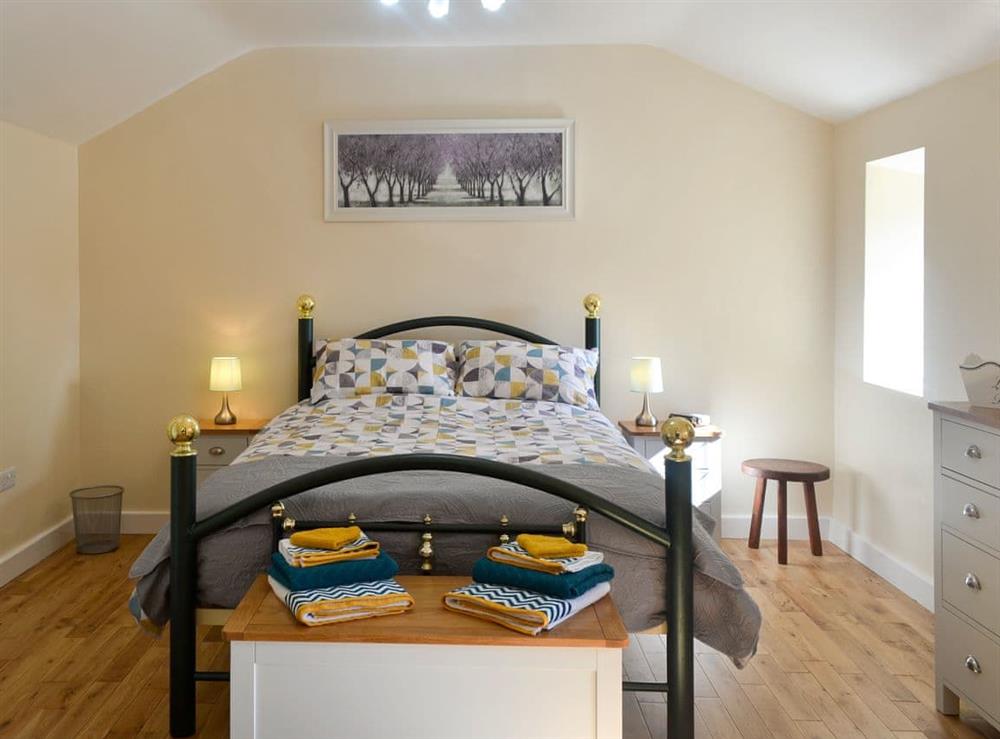 Relaxing bedroom with kingsize bed at Penrhos Bach in Carmel, near Llangefni, Anglesey, Gwynedd