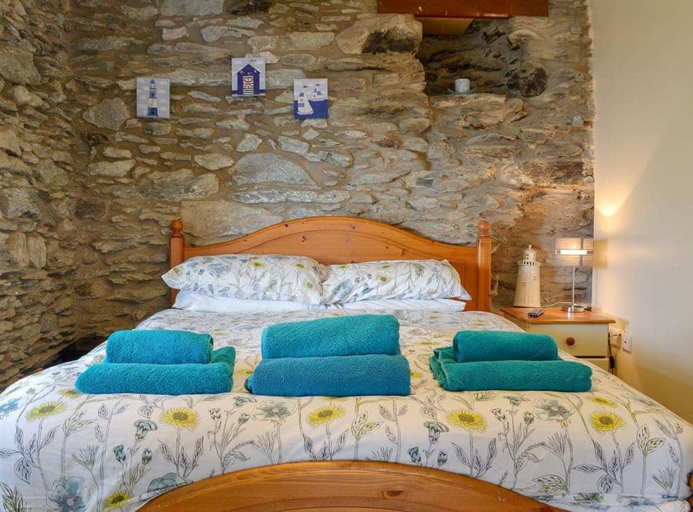 Exposed stone feature walls in double bedroom at Penteryfn in near Holyhead, Isle of Anglesey, Gwynedd