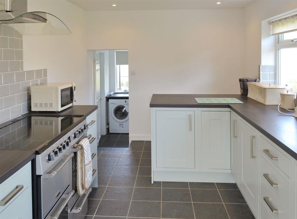 Well-equipped fitted kitchen leading to utility room at Penteryfn in near Holyhead, Isle of Anglesey, Gwynedd
